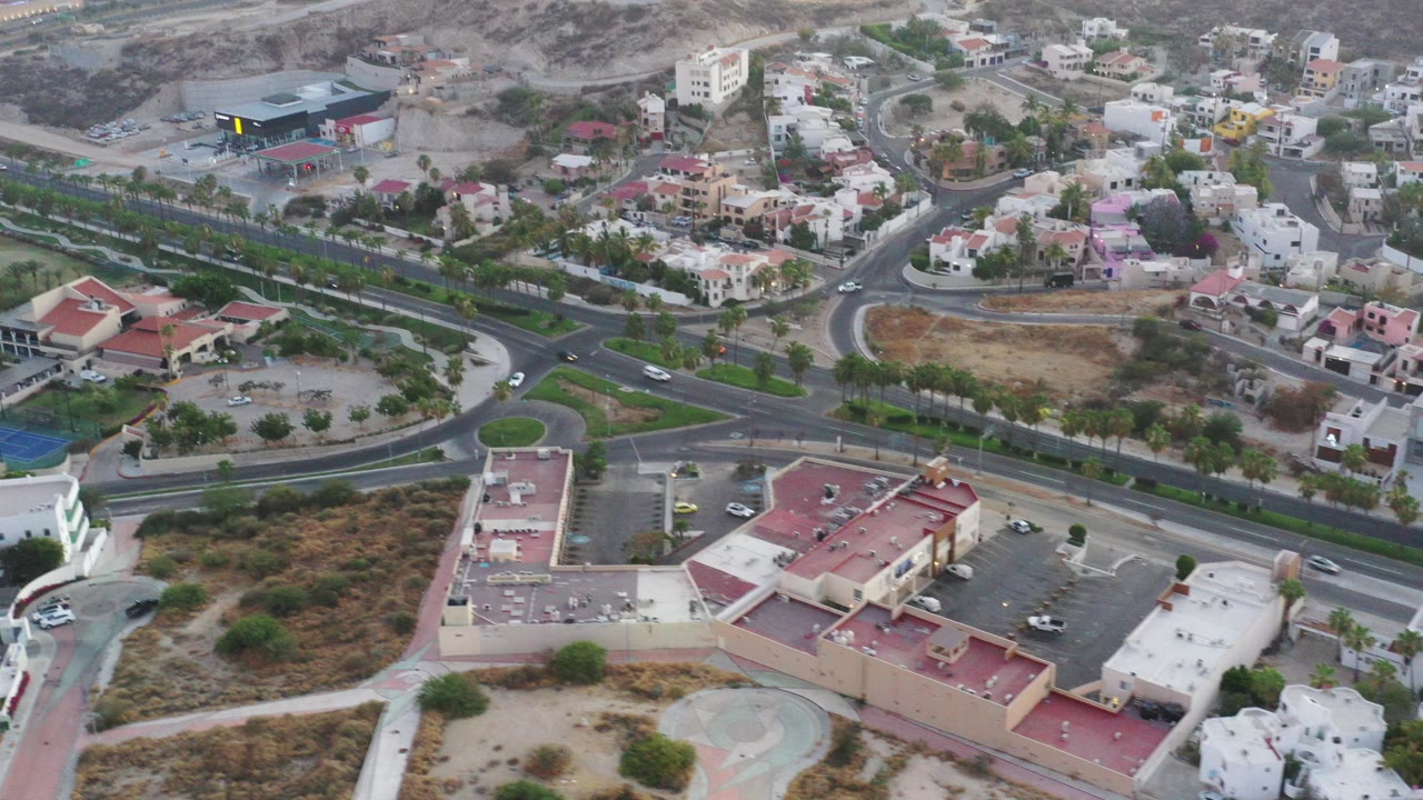 Aerial view of roads, houses, tennis courts, and dry hills.