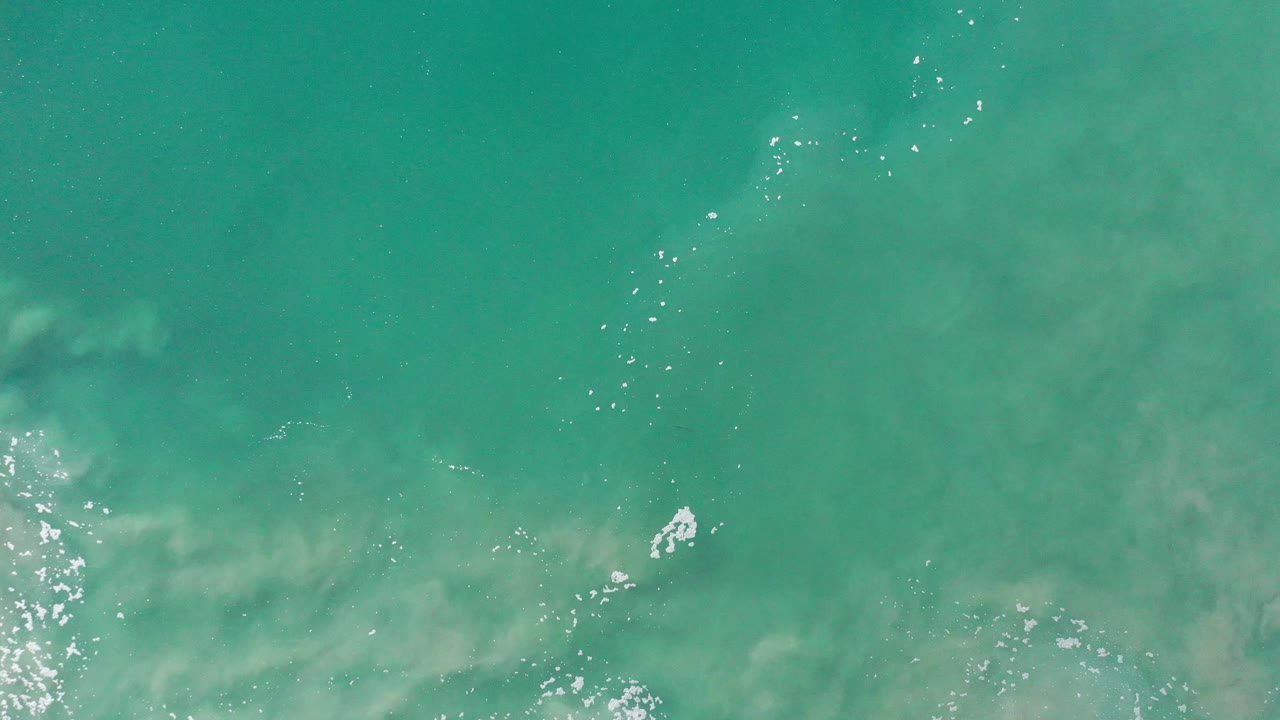 Turquoise-green water with soft cloudy bands beneath the surface