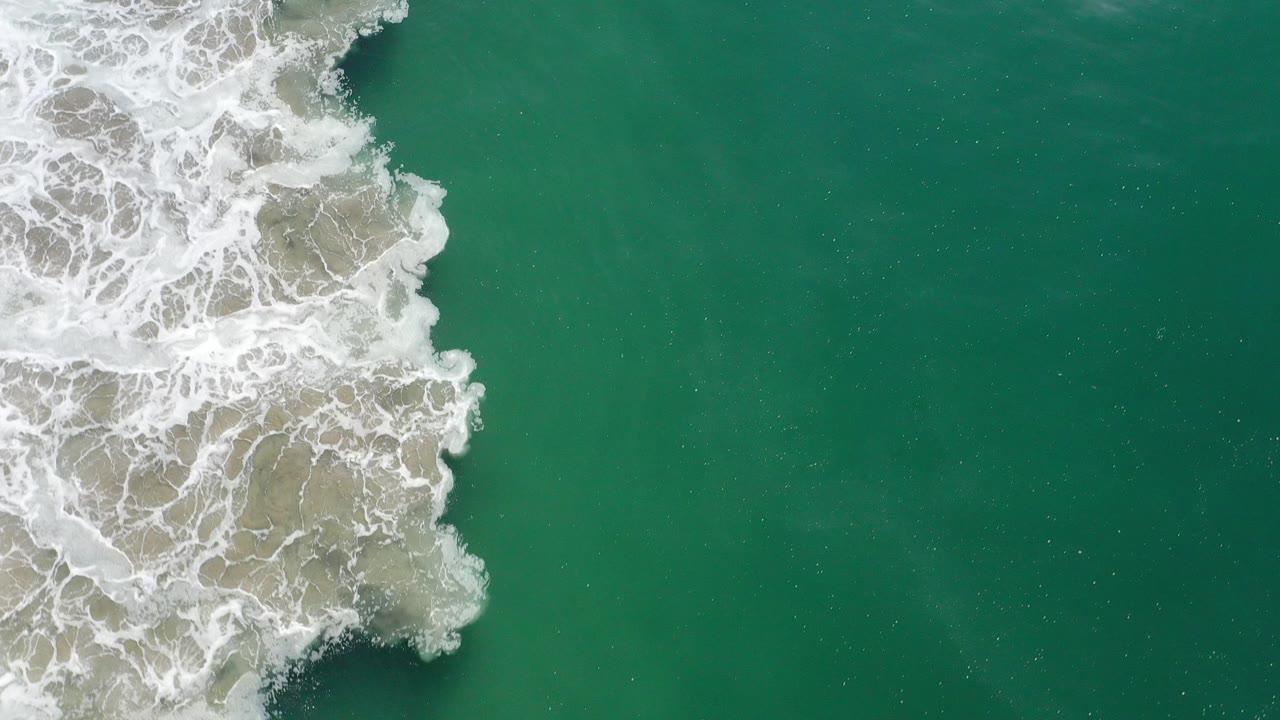 Overhead green ocean with white surf entering from the left.