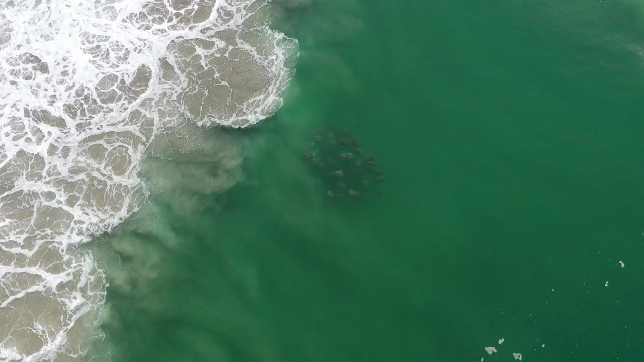 Overhead surf foam and green ocean water