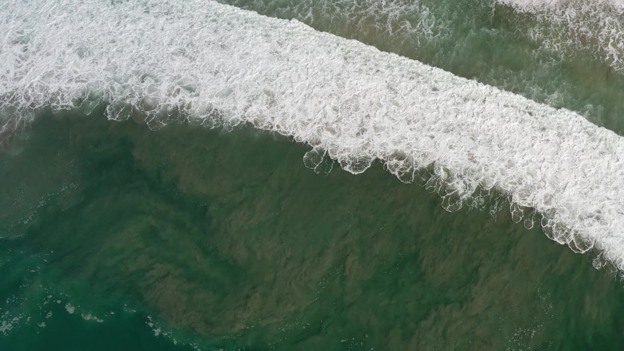 Wide foamy breaker seen directly from above.