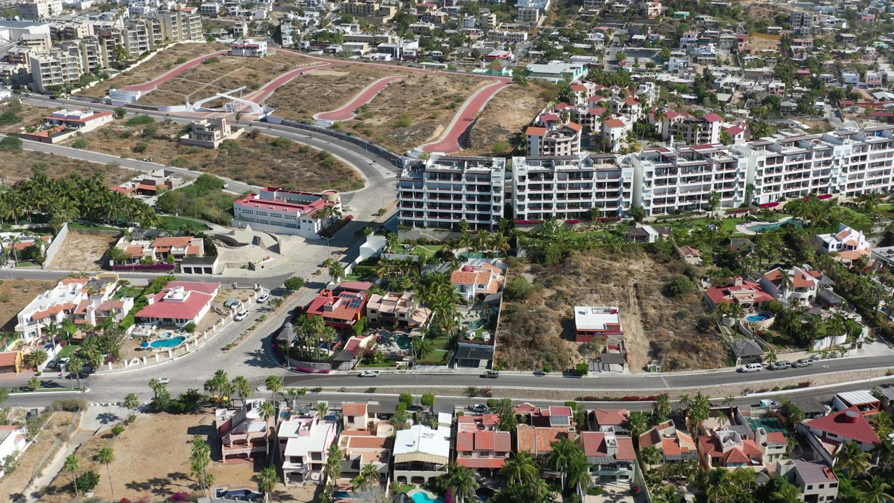 Aerial view of apartment buildings, roads, houses, and dry open lots.