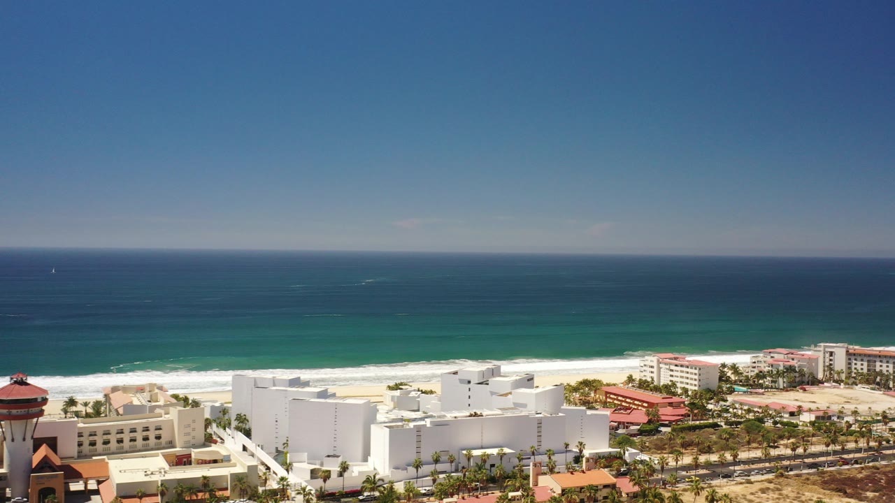 Elevated view of ocean, beach, and coastal buildings.