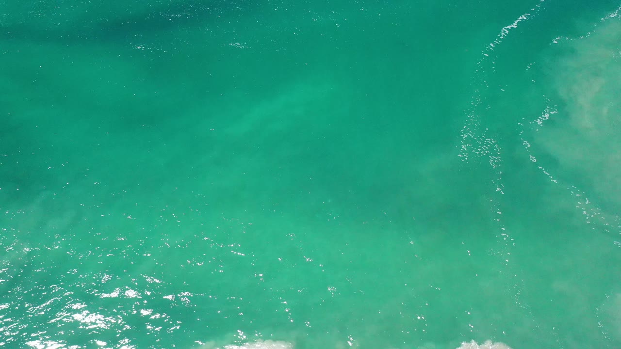 Teal water surface with diagonal ripple lines and soft light.