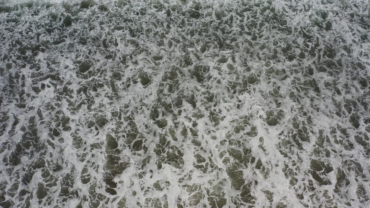Foamy waves filling the overhead frame.