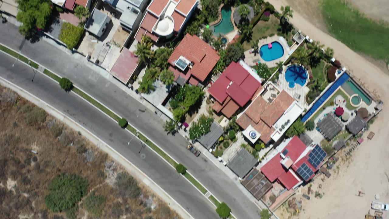 Top-down residential area with pools and road.