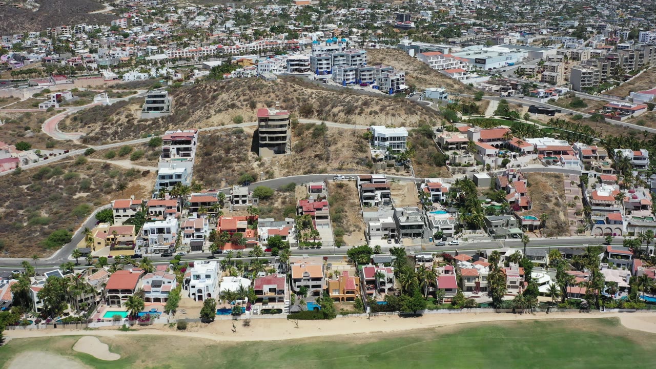 Aerial view of hillside homes, roads, and dry terrain.