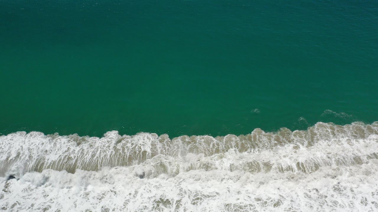 Overhead teal ocean with white surf along the lower edge