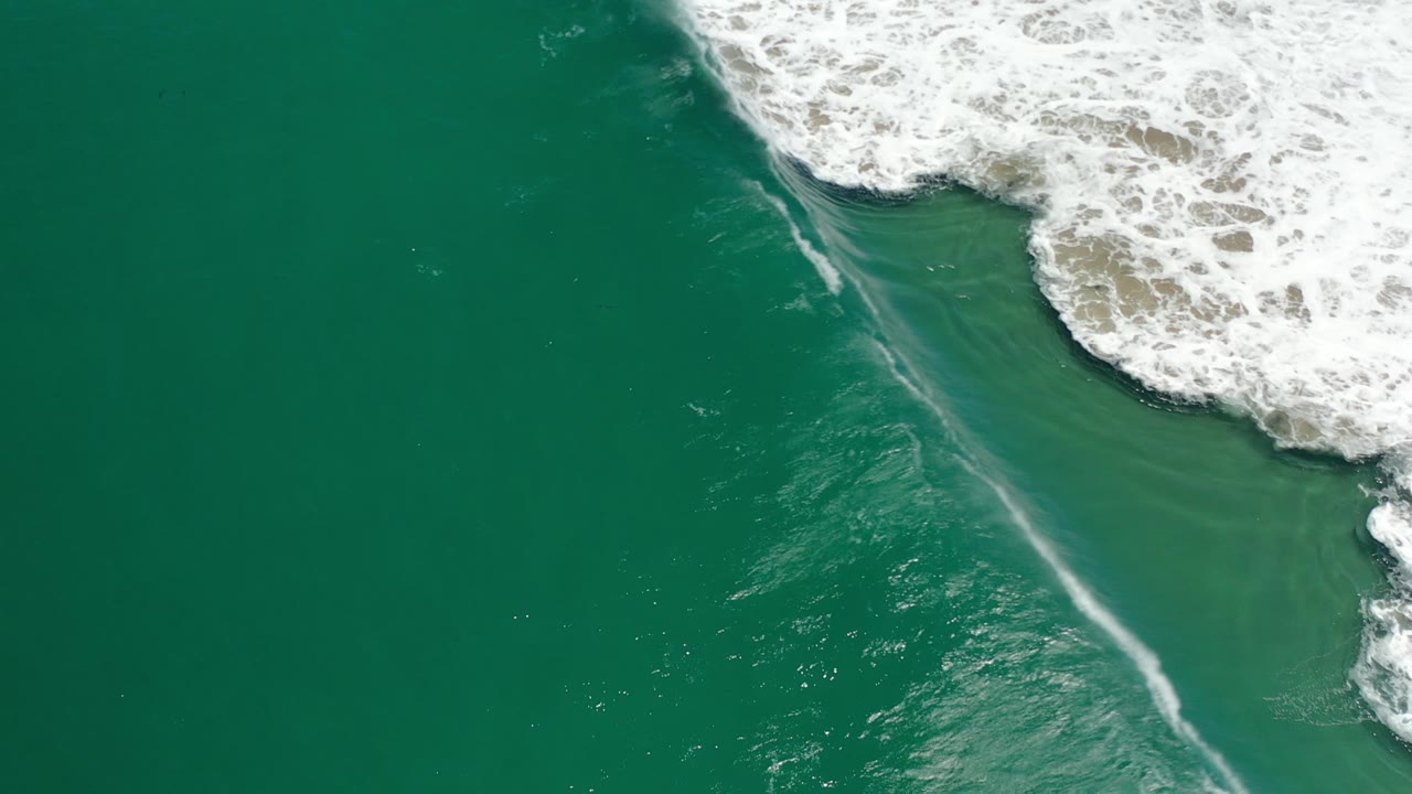Overhead surf foam with a pale streak through green water