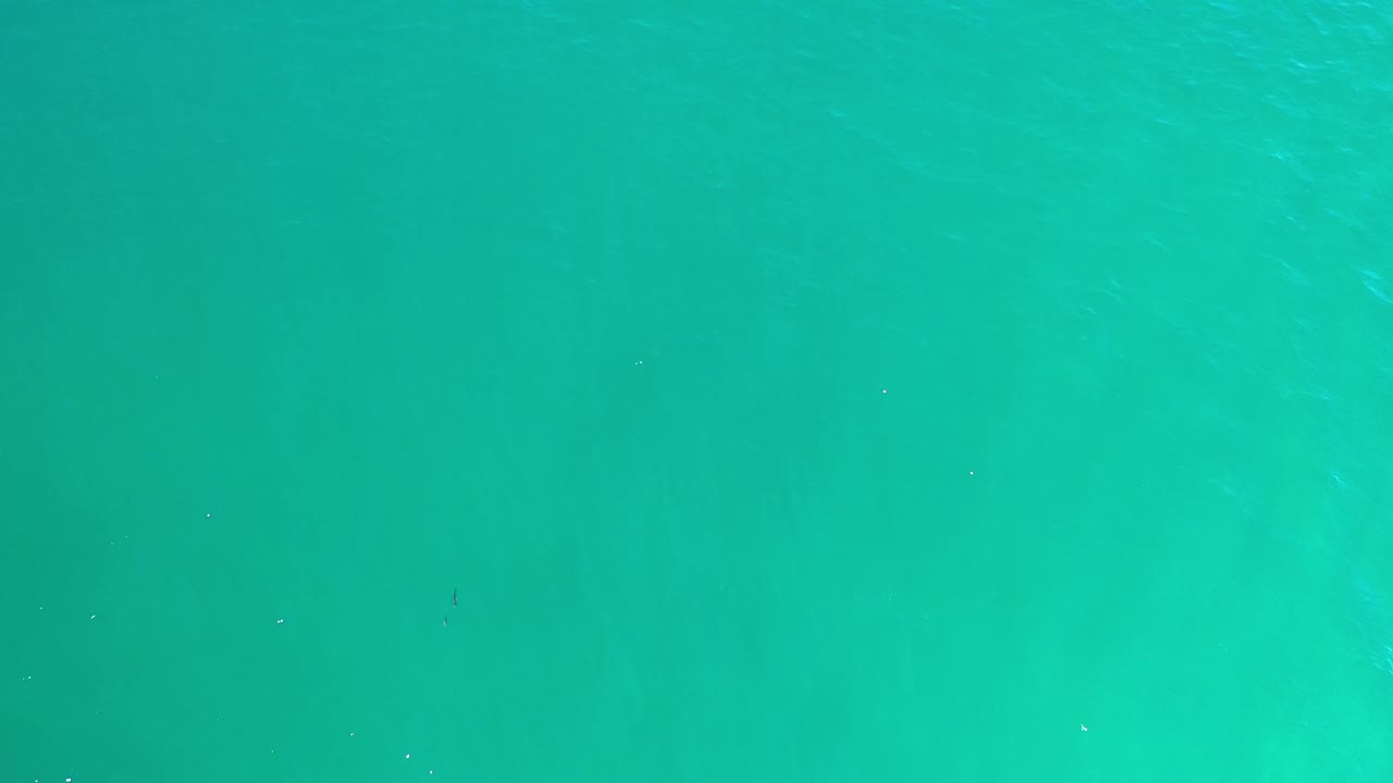 Blue-green ocean surface in Los Cabos, Mexico, seen from above with scattered white glints and no visible people.
