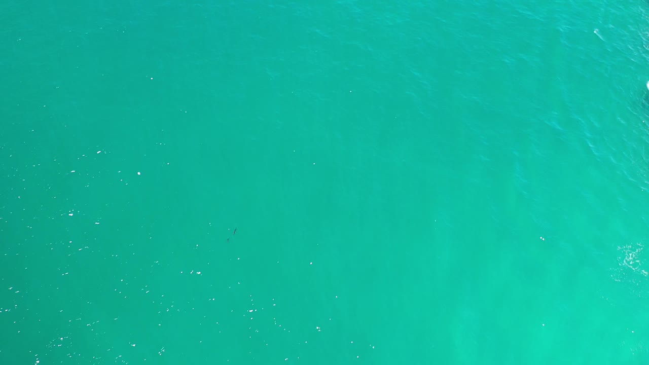 Clear turquoise water with darker bands below.