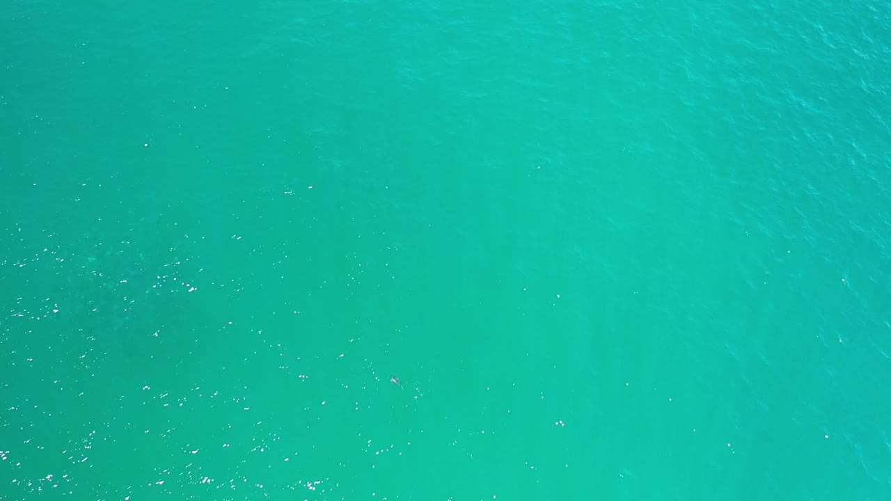 Aqua water surface with faint wave streaks.