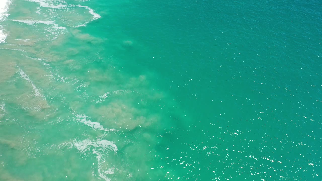 Turquoise water with cloudy shallows and scattered highlights.