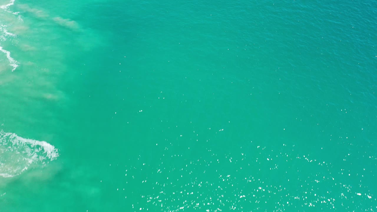 Open turquoise water with small surf near the upper left.
