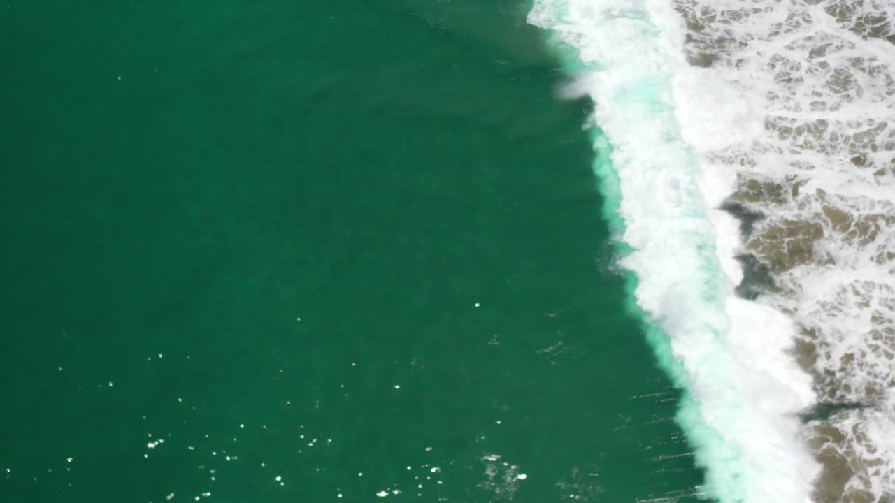 Overhead green ocean with white surf along the right edge