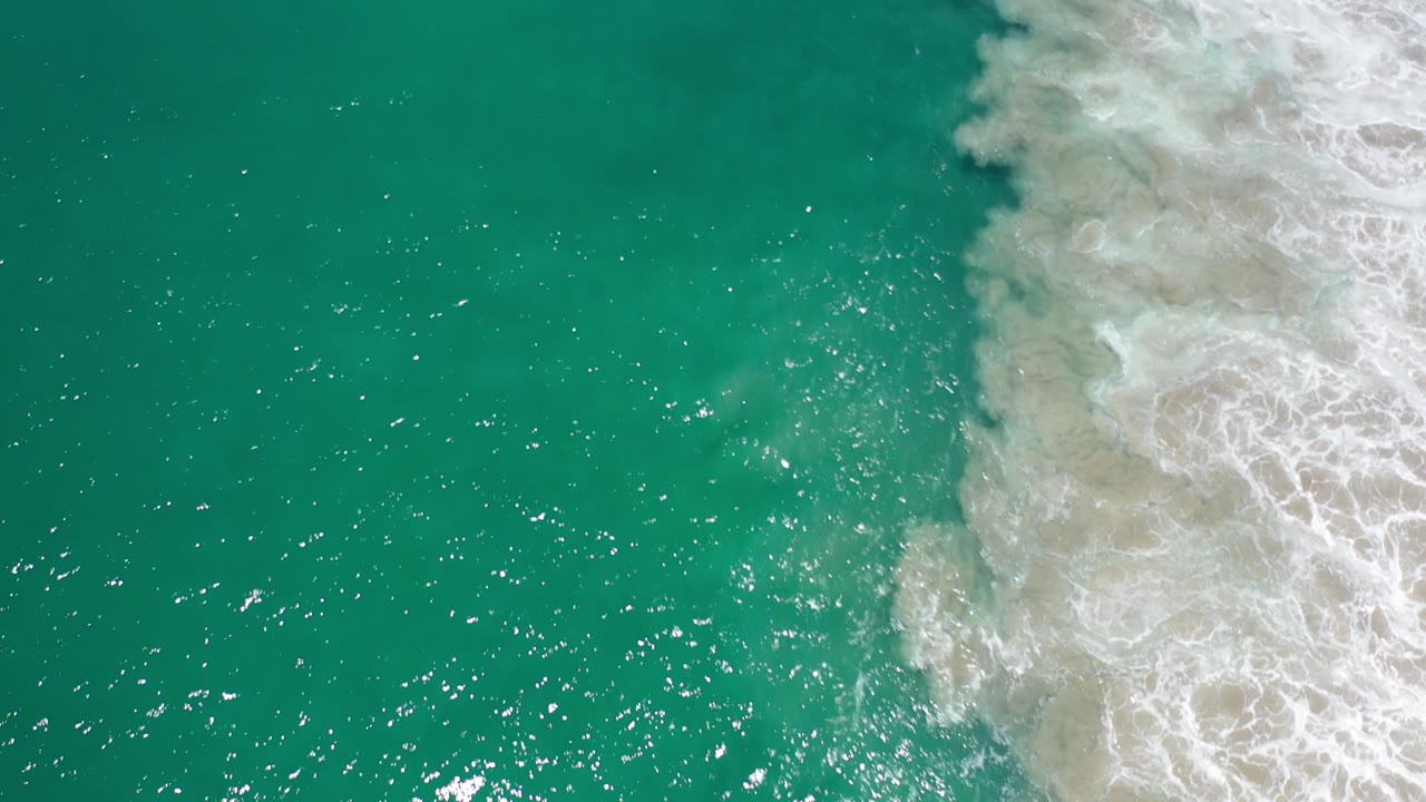 Green ocean water with broken white surf near the upper right.