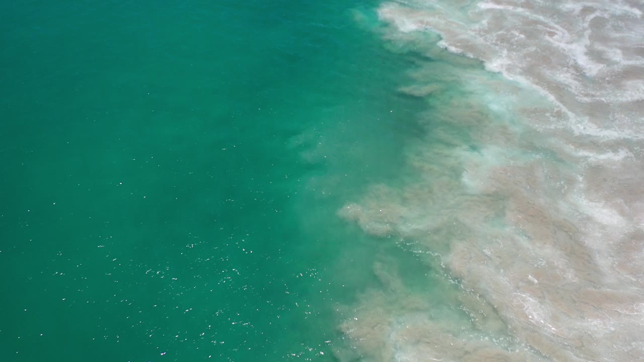 Overhead green sea with white surf foam at the upper right.