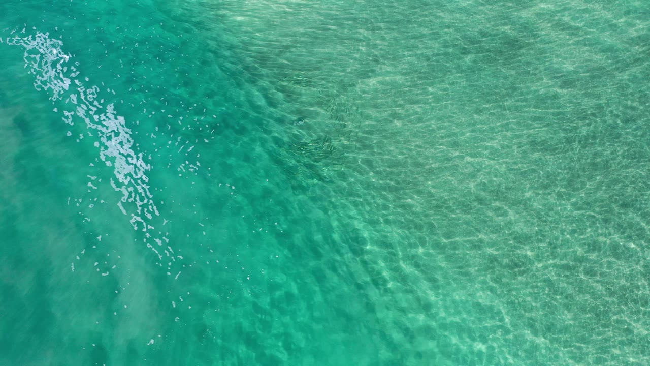 Overhead green water with a broken white foam line near the top left.