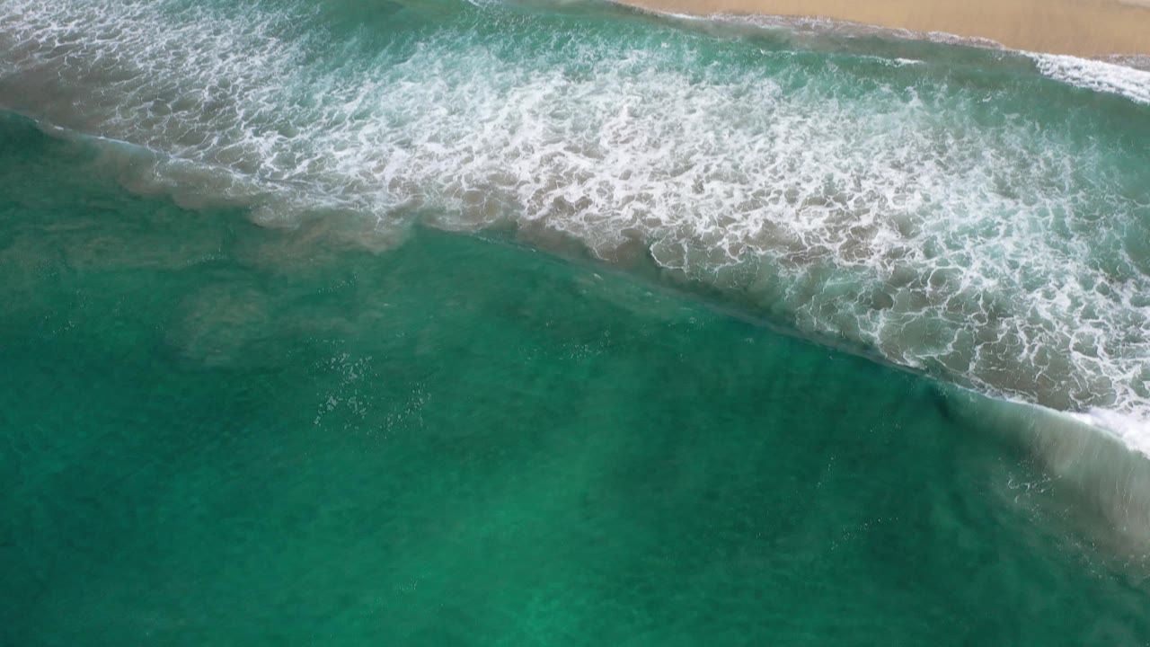 White wave wash over turquoise water near beach