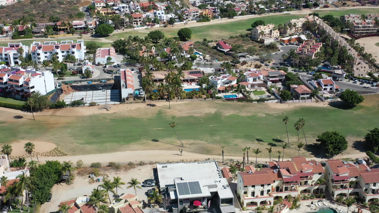 Downward aerial view of homes beside a golf fairway.