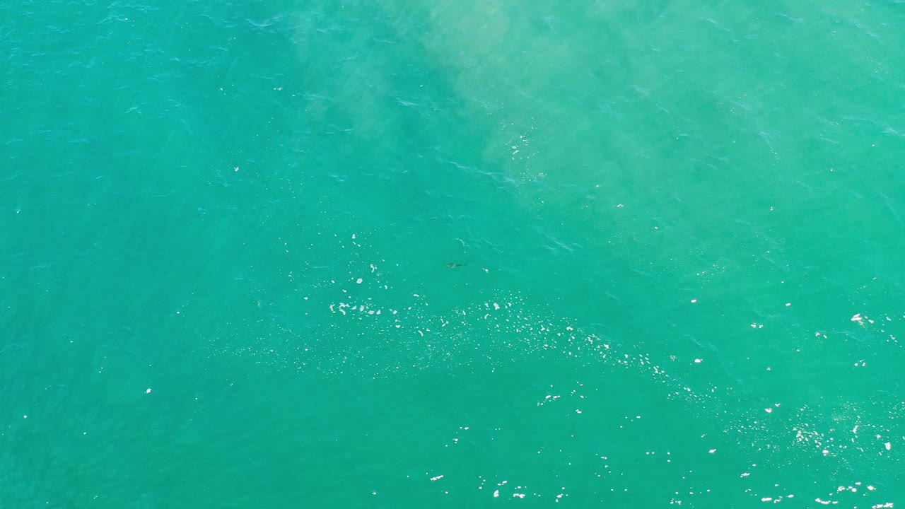 Overhead view of turquoise seawater in Los Cabos, Mexico, with scattered white highlights near the lower edge and no visible people.