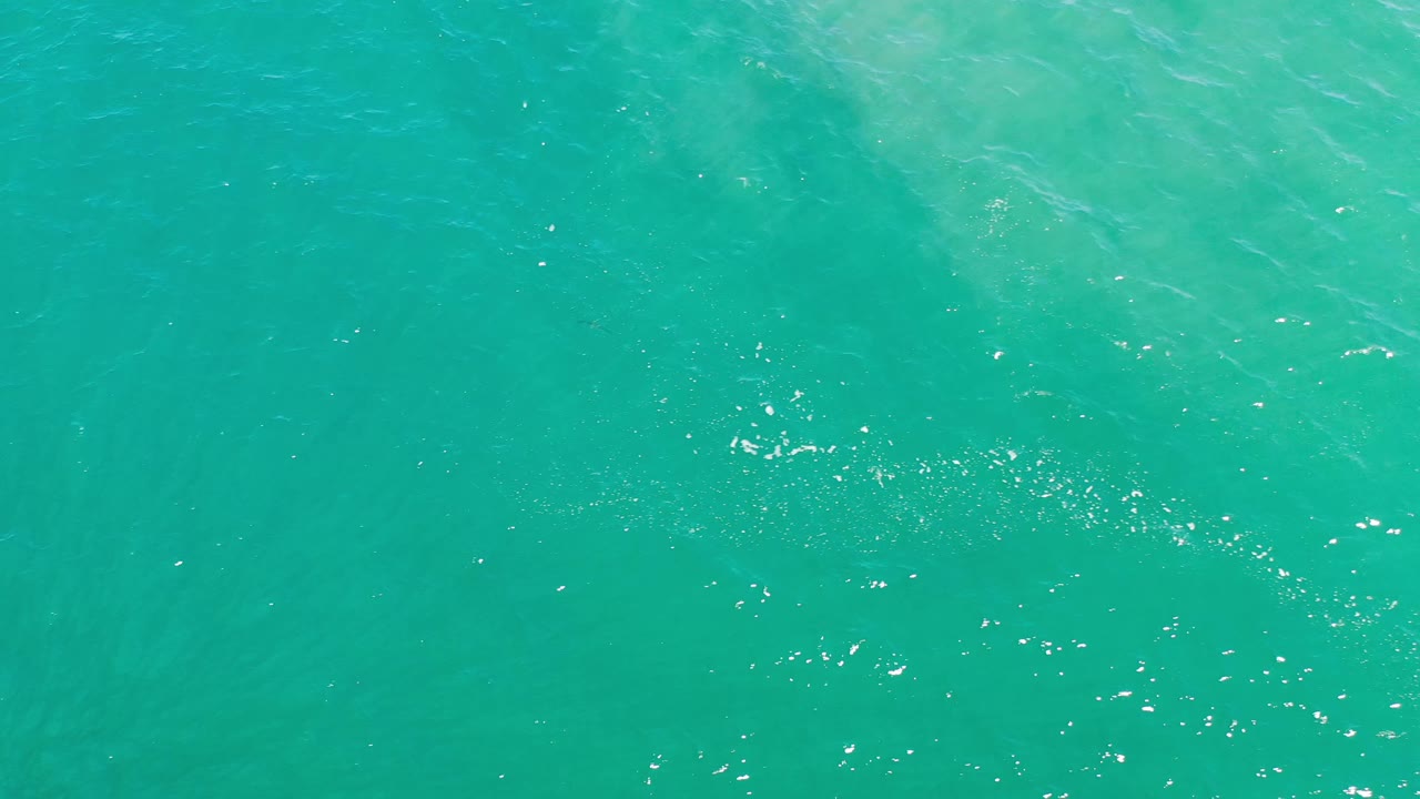 Blue-green ocean surface in Los Cabos, Mexico, with faint diagonal wave texture and no visible people.