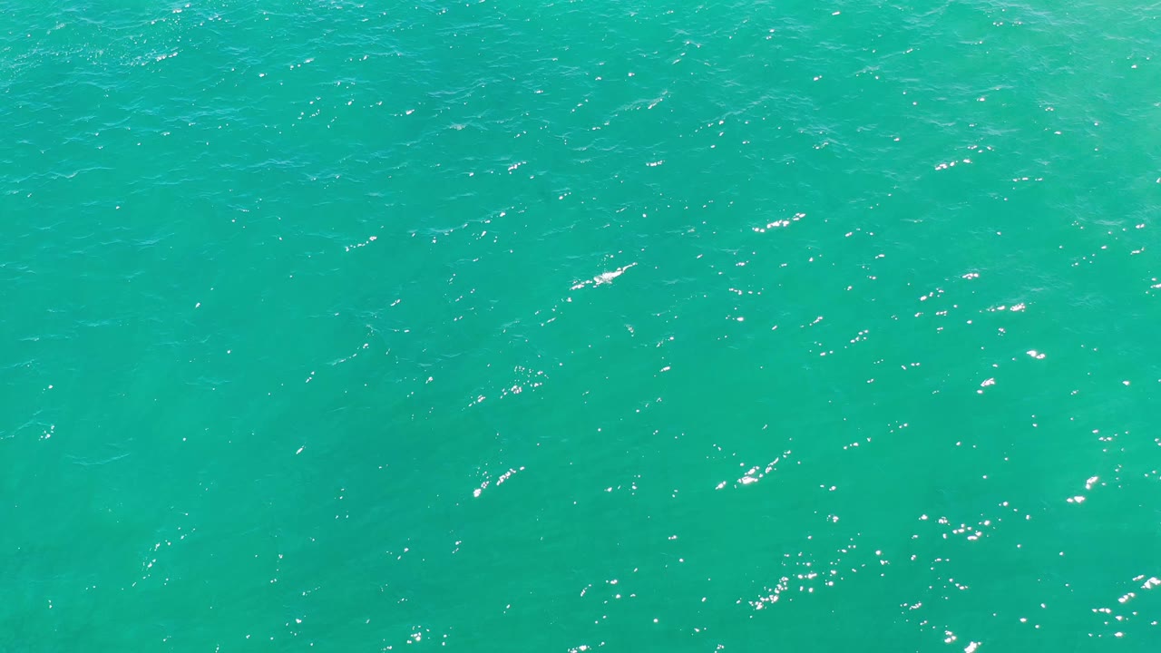 Blue-green ocean surface in Los Cabos, Mexico shows fine ripple patterns and small points of reflected light, with no visible people or shoreline.