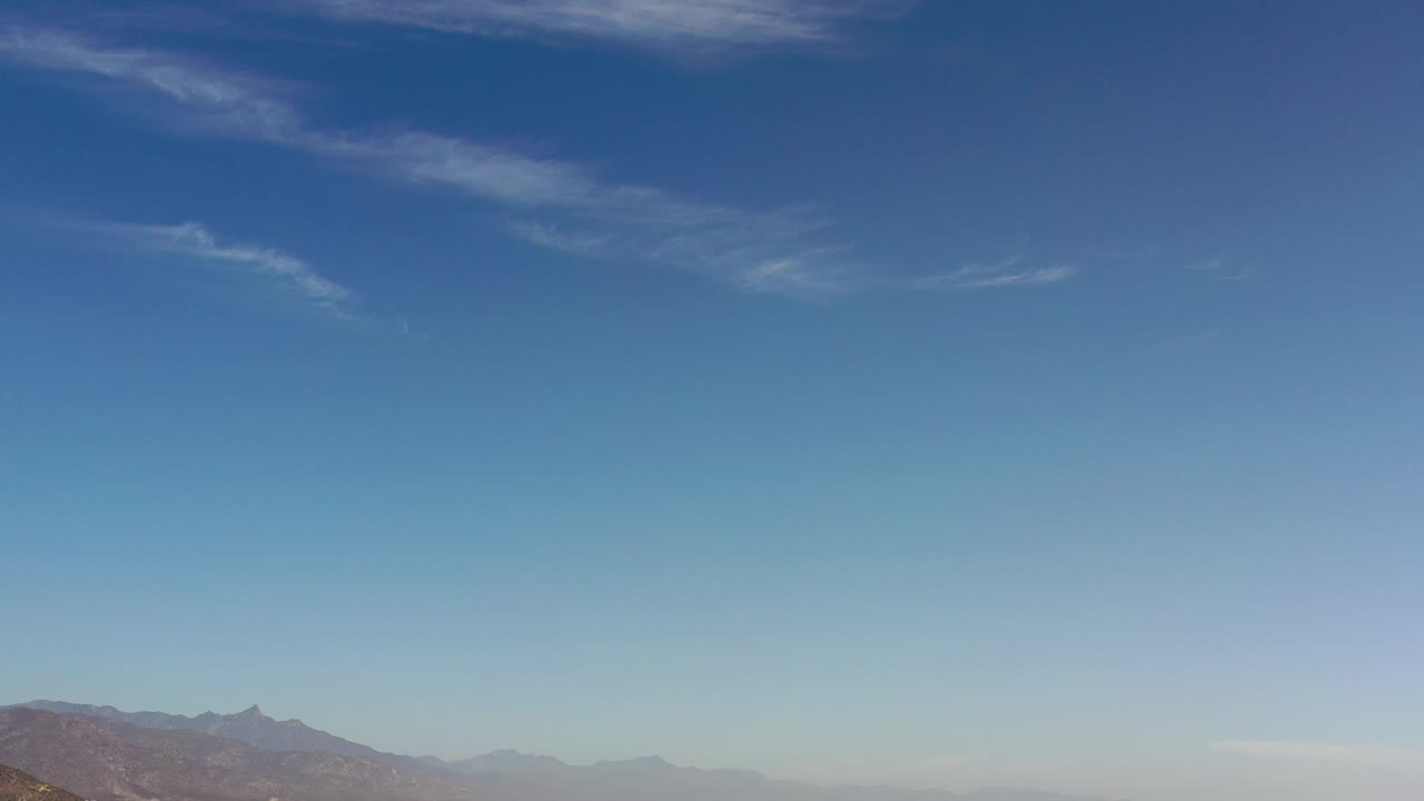 Mountain ridge below a large blue sky.