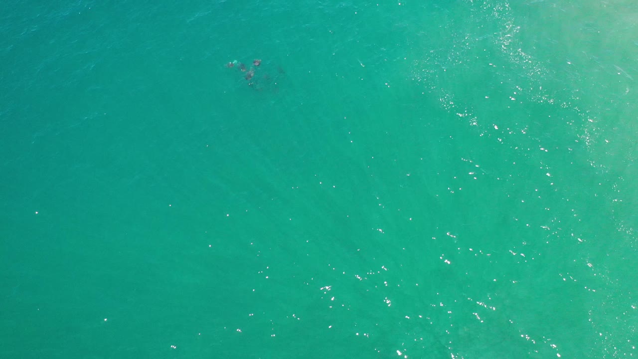 Aerial ocean water with pale underwater haze and surface shimmer.