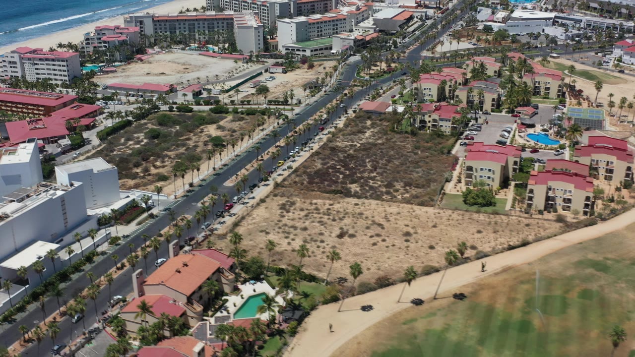 Drone view of Los Cabos resort area beside beach and golf fairway.