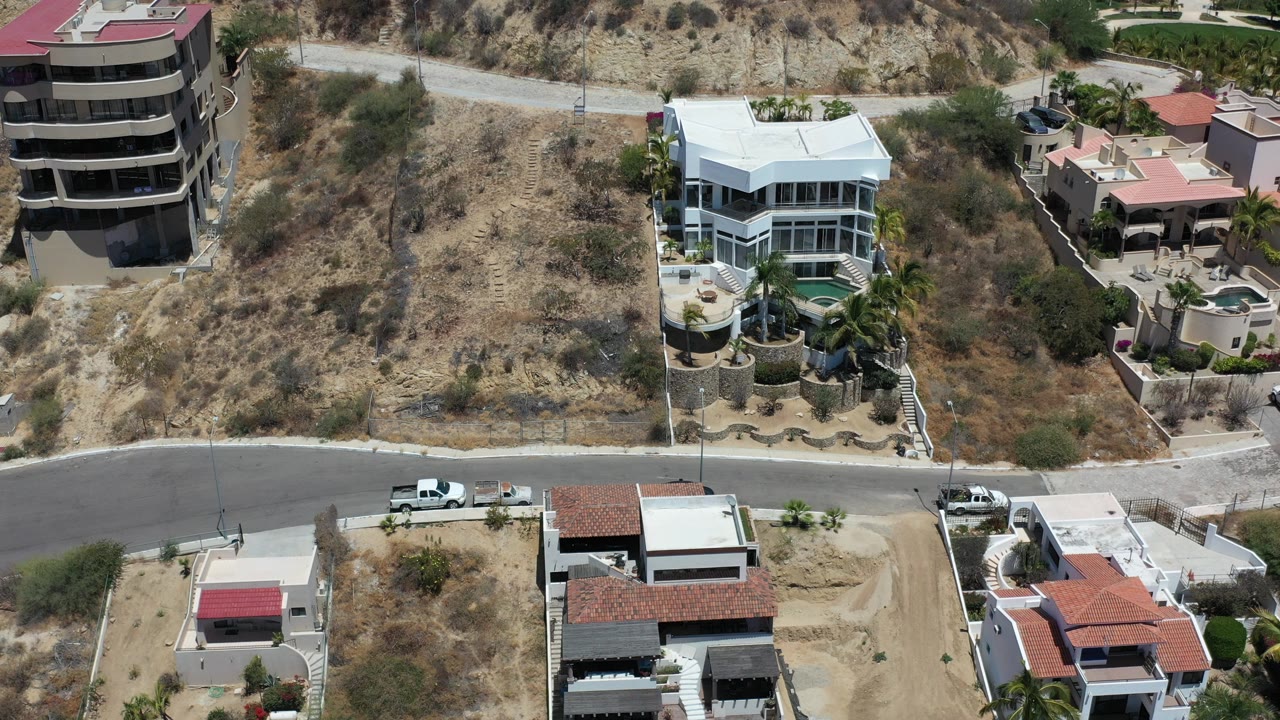 Aerial view of hillside homes beside a curved road