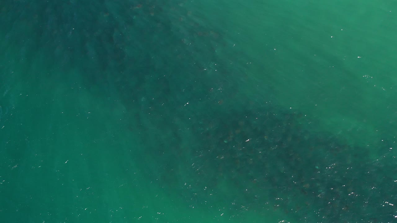 Teal ocean water with darker underwater patches