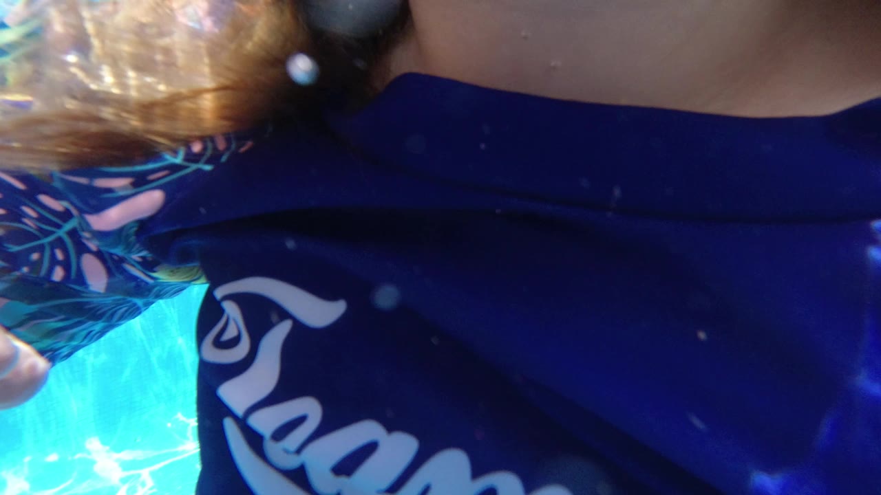 Close underwater view of child in blue swim top