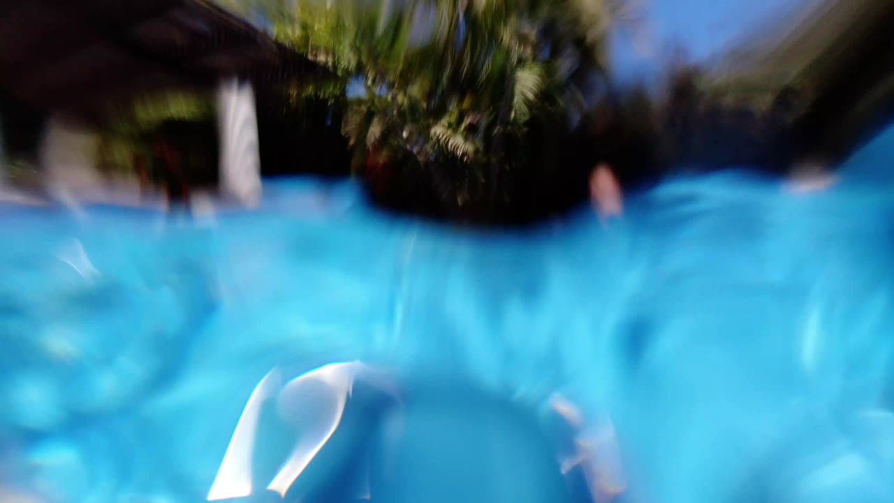 Blurred waterline view inside a bright blue pool.