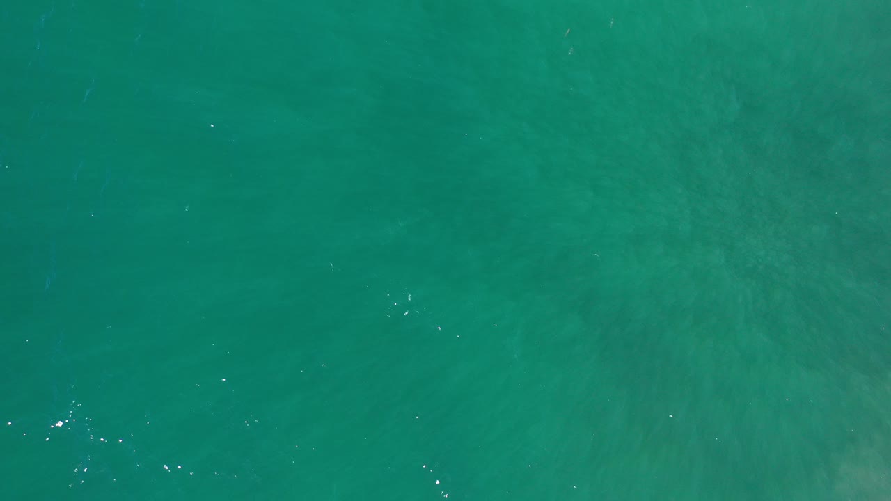 Overhead view of green-blue ocean water near Los Cabos, Mexico, with faint surface sparkle and no visible people.