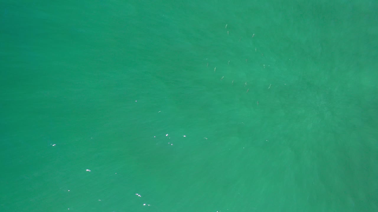 Overhead teal water surface in Los Cabos, Mexico, with soft ripples, subtle underwater color variation, and no visible people.