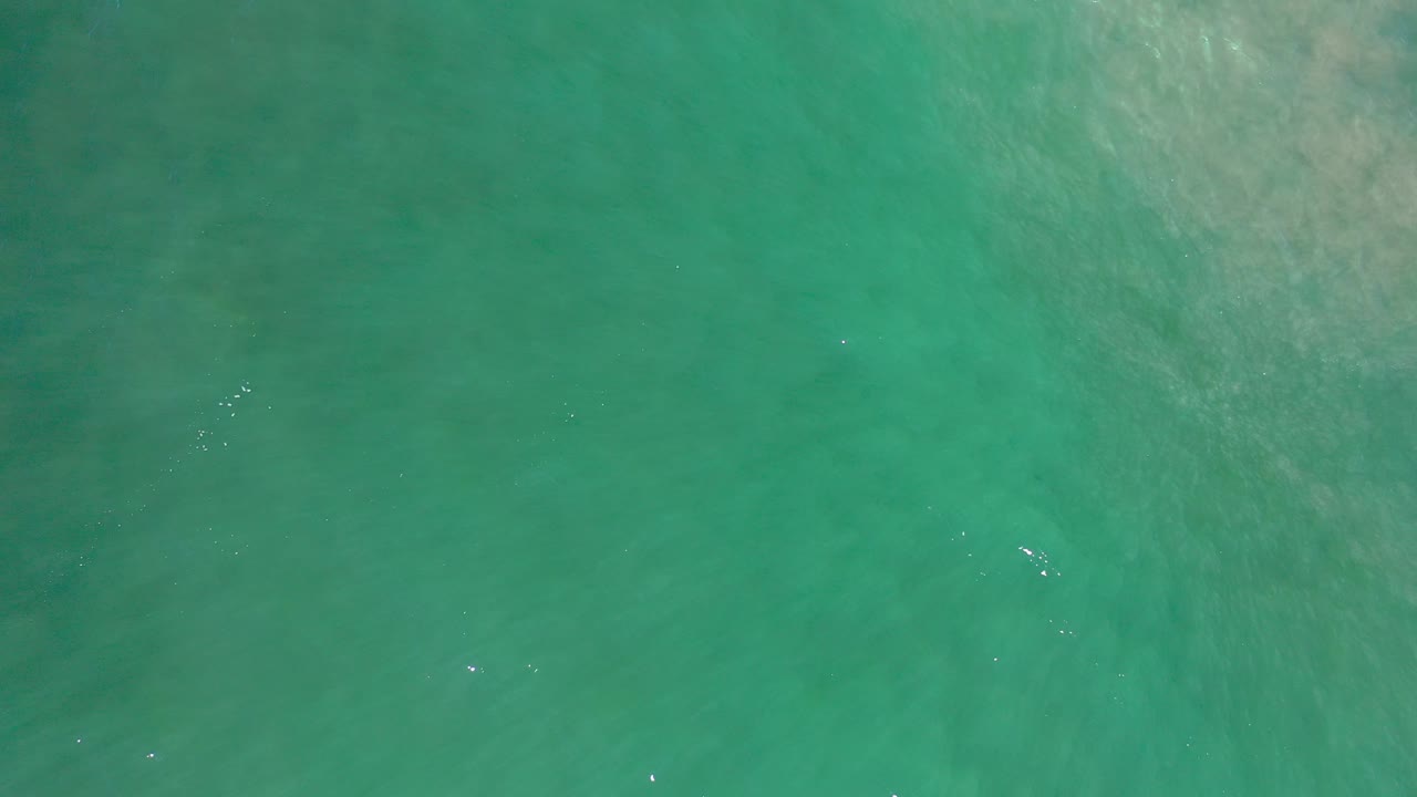 Teal water with pale diagonal wave texture.