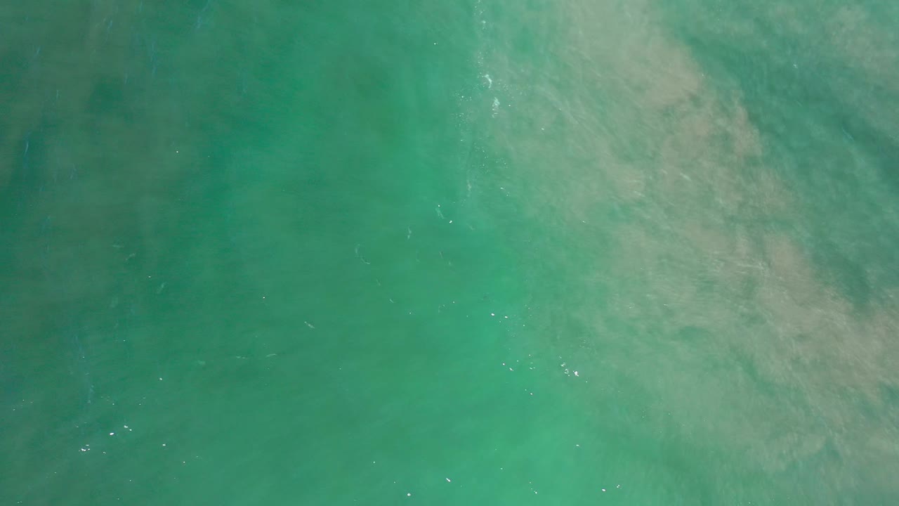 Green-blue water with pale cloudlike texture across the top right.