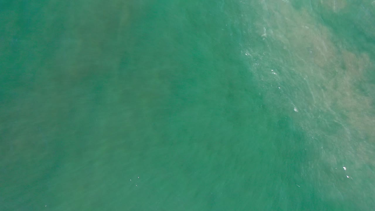 Overhead view of blue-green ocean near Los Cabos, Mexico, with pale underwater patches and no visible people.