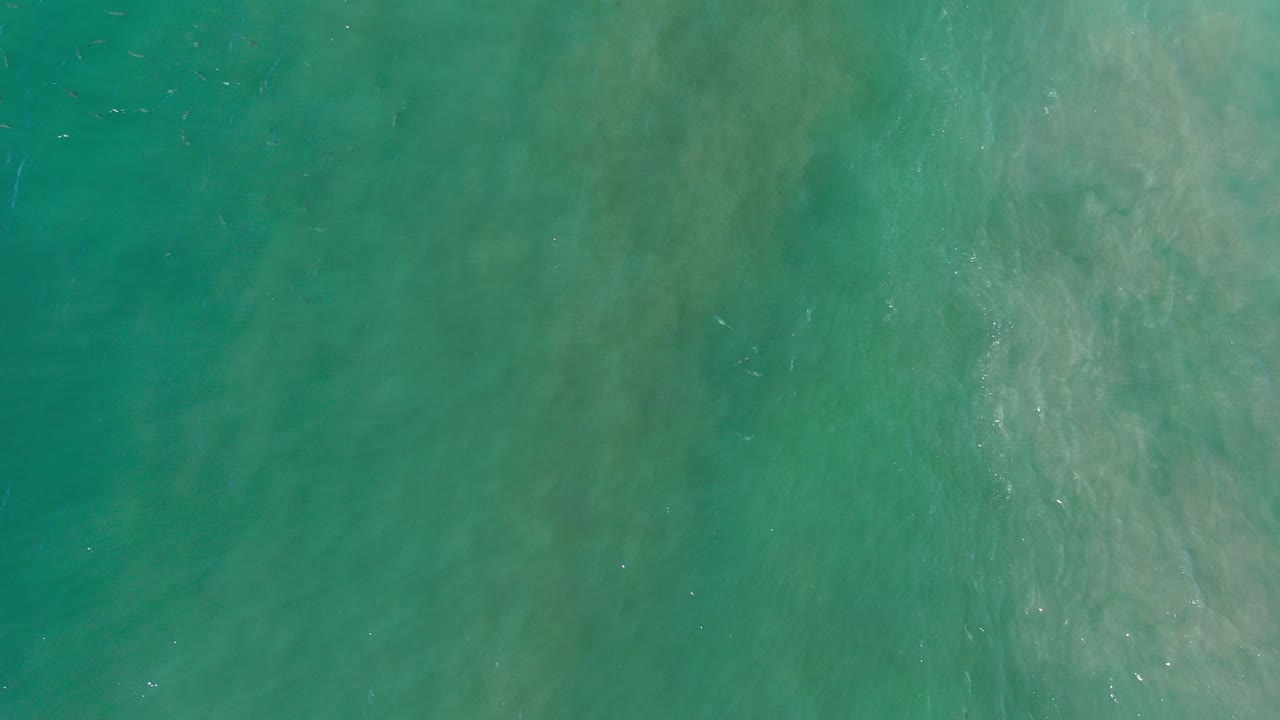 Overhead view of turquoise ocean water in Los Cabos, Mexico, with pale submerged streaks and no visible people.