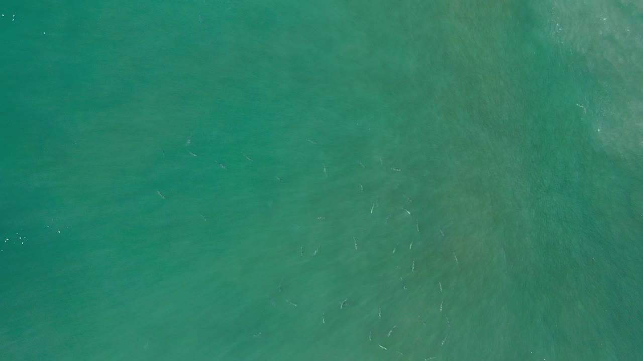 Overhead view of turquoise shallow water in Los Cabos, Mexico, with faint wave streaks and no visible people.