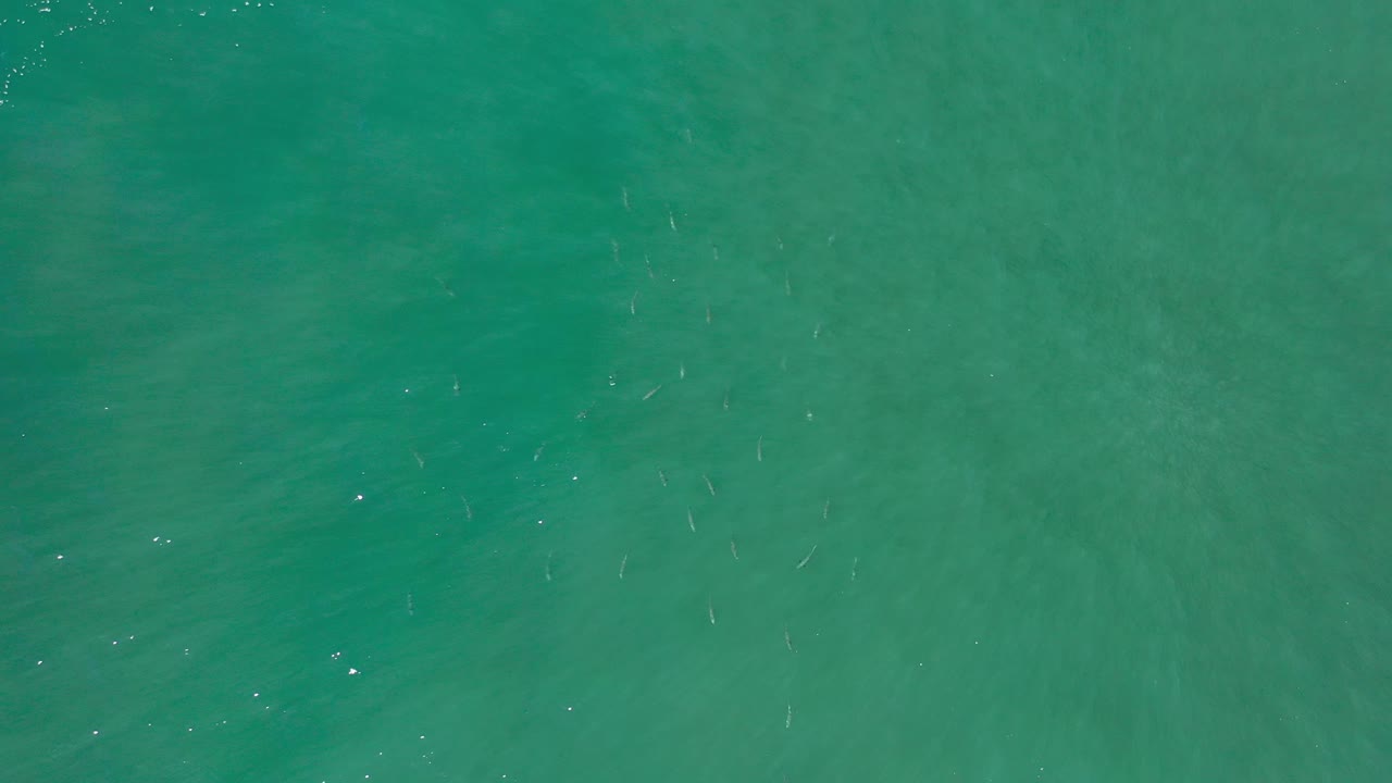 Aerial ocean water with soft darker streaks below the surface.