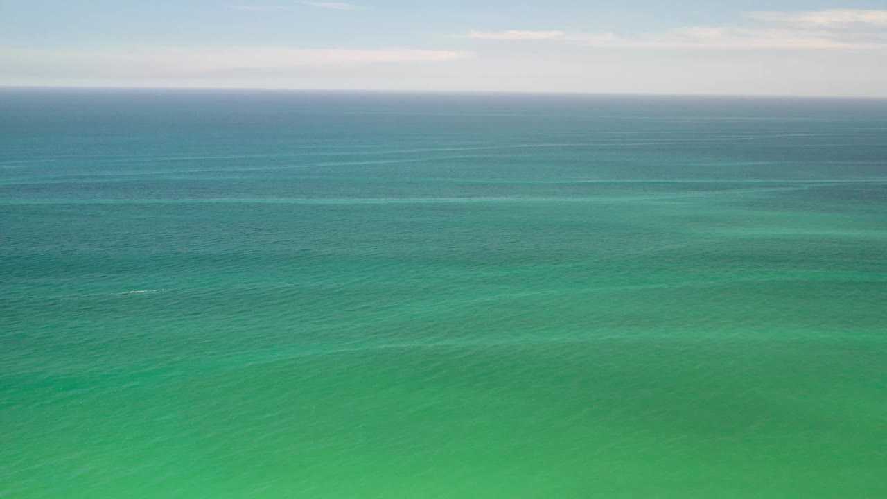 Second frame shows the Los Cabos sea as broad horizontal bands of aqua and teal under a lightly clouded sky, with no visible people.