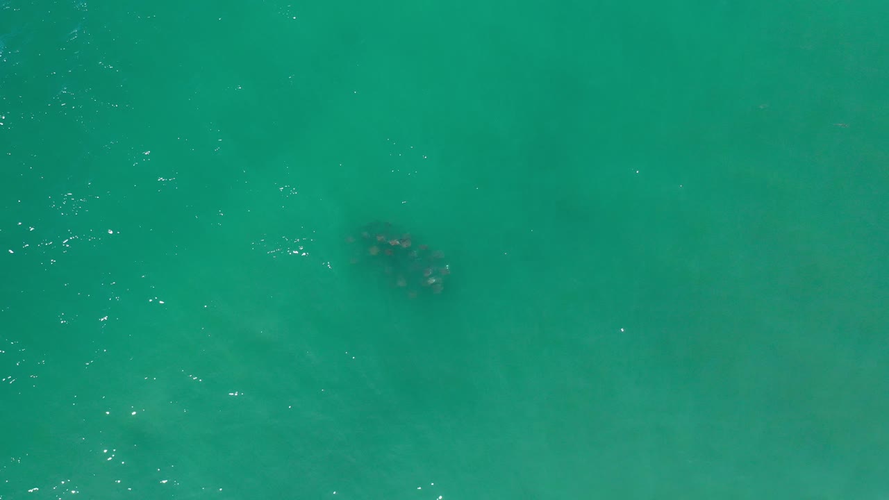 Aerial water surface with darker patch at upper right