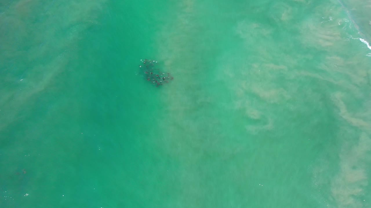 Turquoise water with a dark underwater cluster near the upper left area.