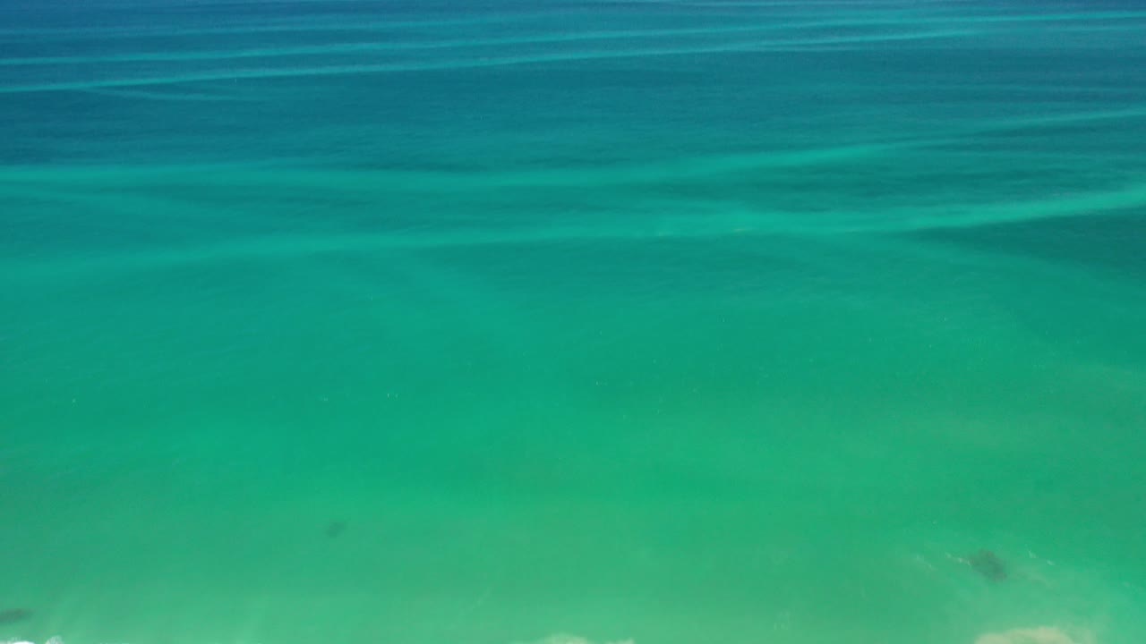 Turquoise ocean water fills the frame with faint surface bands.