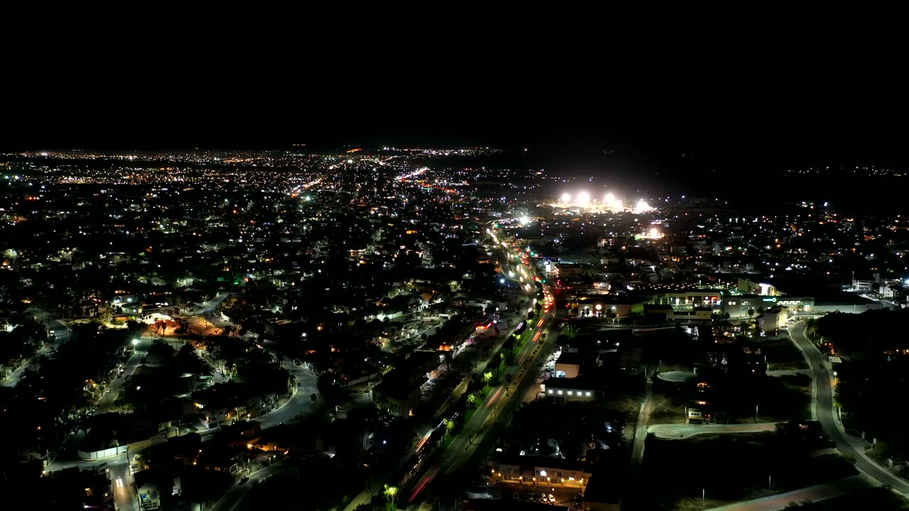 Night aerial view of illuminated city roads and buildings