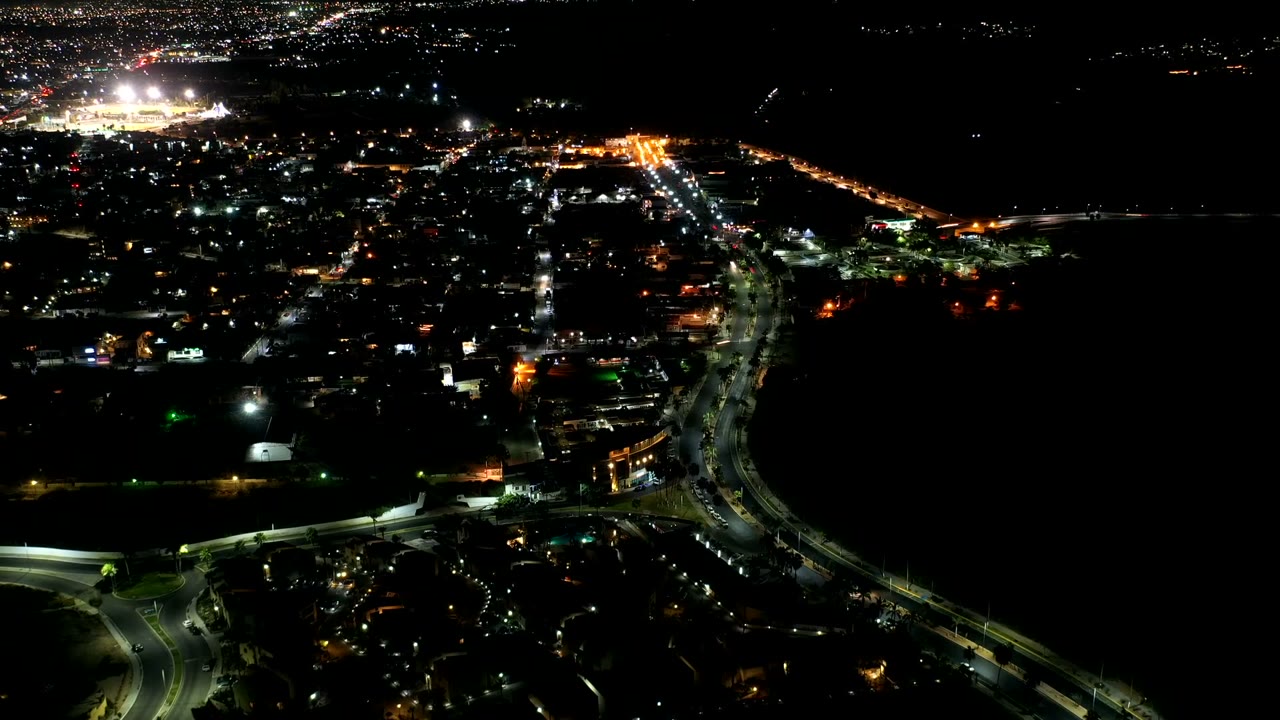 Nighttime aerial frame with traffic lights running through a town grid.