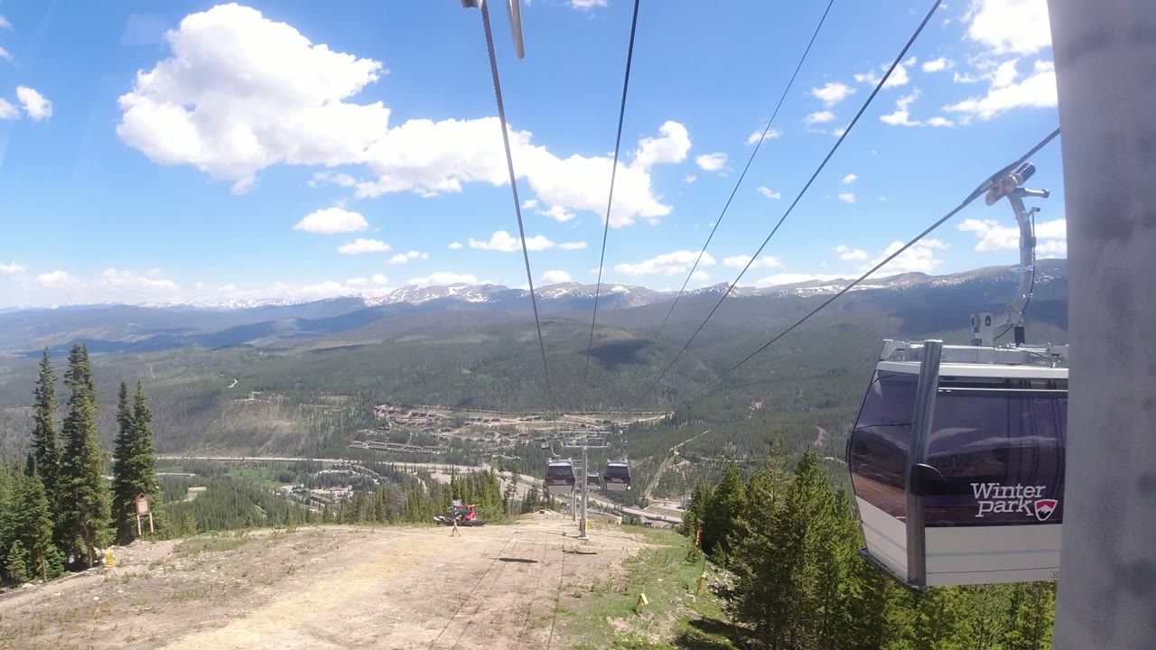 Gondola cabin beside cables above a mountain valley