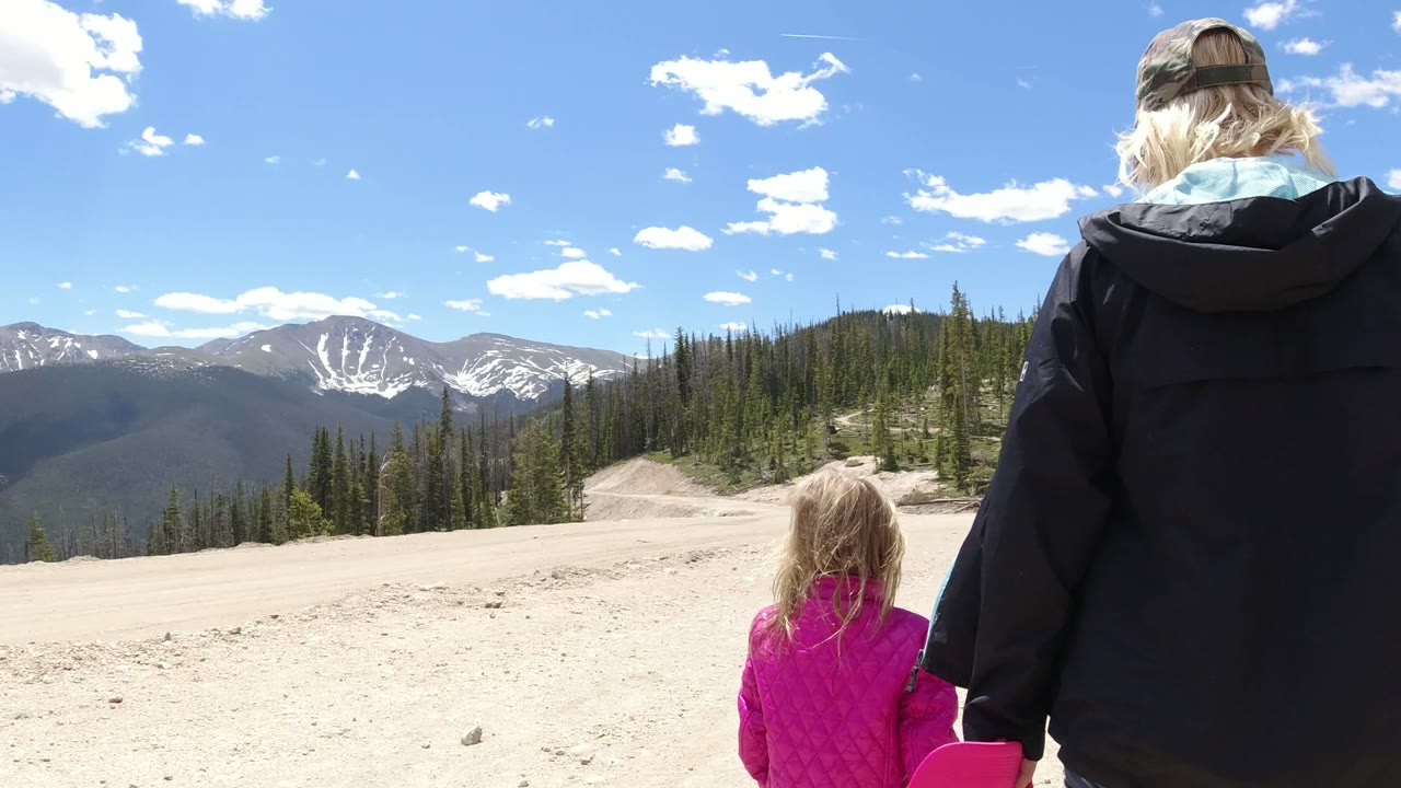 Woman and child seen from behind near mountains